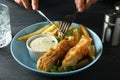 Female hands hold cutlery over the fried fish and chips, close up Royalty Free Stock Photo