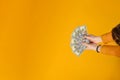Female hands hold dollar bills in their hands, on a yellow background Royalty Free Stock Photo