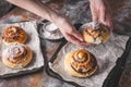 Female hands hold a fresh sweet homemade cinnamon roll with chocolate cream. Scandinavian cuisine. Hyugge style