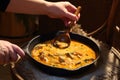 Female hands hold a frying pan with stewed meat