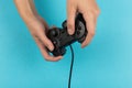 Female hands hold a gamepad on a blue background. Weekend concept, gaming hobby. Copy space Royalty Free Stock Photo