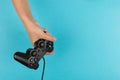 Female hands hold a gamepad on a blue background. Weekend concept, gaming hobby. Copy space Royalty Free Stock Photo