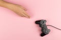 Female hands hold a gamepad on a pink background. Weekend concept, gaming hobby. Copy space Royalty Free Stock Photo