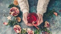 Female hands hold a glass of mulled wine with pomegranate. Traditional Christmas Wine Drink. Top view Royalty Free Stock Photo