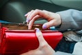 Female hands hold modern red money purse for women