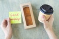 female hands hold note with words GOOD morning, cup of coffee, keyboard, cactus and mause on a wooden table. concept of Royalty Free Stock Photo