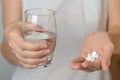 female hands hold pills and a glass of water Royalty Free Stock Photo