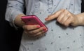 Female hands hold a pink smartphone in their hands. Girl runs her finger on the phone