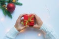 Female hands hold a red gift box tied with a gold ribbon. The concept of gifts for Christmas and New Year Royalty Free Stock Photo