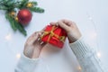 Female hands hold a red gift box tied with a gold ribbon. The concept of gifts for Christmas and New Year Royalty Free Stock Photo