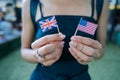 Female hands hold small flags of two countries Royalty Free Stock Photo