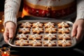 Female hands hold tray with baked Christmas cookies