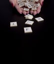 Female hands holding alphabet toy blocks on black background