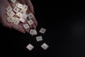 Female hands holding alphabet toy blocks on black background