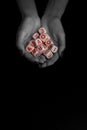 Female hands holding alphabet toy dices on black background