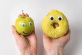 Female hands holding apple and donut with funny faces and huge eyes. Proper nutrition concept Royalty Free Stock Photo