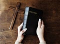 Female hands holding a bible and a wooden cross Royalty Free Stock Photo