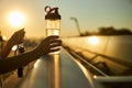 Female hands holding bottle of water and skipping rope Royalty Free Stock Photo