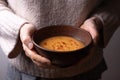 Female hands holding a bowl of vegetarian red lentil cream soup Royalty Free Stock Photo