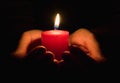 Female hands holding a burning candle in the dark Royalty Free Stock Photo