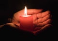 Female hands holding a burning candle in the dark Royalty Free Stock Photo