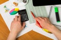 Female hands holding calculator and pencil, notebook, marker, ac Royalty Free Stock Photo