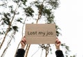 Female hands holding cardboard with text LOST MY JOB outdoors. Nature background. Protester activist