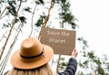 Female hands holding cardboard with text SAVE THE PLANET outdoors. Nature background. Protester activist