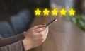 Female hands holding cellphone with customer review