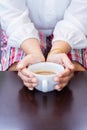 Female hands holding coffee cup on wooden table Royalty Free Stock Photo