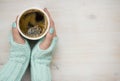 Female hands holding a coffee mug in knitted mittens Royalty Free Stock Photo