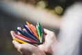 Female hands holding colorful pencils in the park. Bunch of multicolored crayons in hand Royalty Free Stock Photo