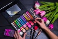 Female hands holding cosmetic brush with eyeshadow palette and b Royalty Free Stock Photo