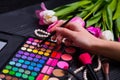 Female hands holding cosmetic brush with eyeshadow palette and b Royalty Free Stock Photo