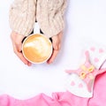 Female hands holding cup of cappuccino. Gift alike dessert with