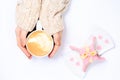 Female hands holding cup of cappuccino. Gift alike dessert with