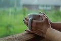 Female hands holding cup of coffee in the rainy day Royalty Free Stock Photo