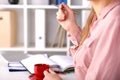 Female hands holding cup of coffee or tea and silver pen Royalty Free Stock Photo