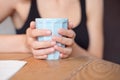 Female hands holding a cup of coofee on the wooden table