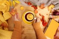 Female hands holding a cup of hot tea or coffee, autumn flat in the Scandinavian hugg style, with yellow leaves, cozy knitwear, Royalty Free Stock Photo