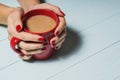 Female hands holding cups of coffee over wooden background, Royalty Free Stock Photo