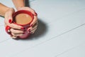 Female hands holding cups of coffee over wooden background, Royalty Free Stock Photo