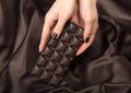 Female hands holding the dark chocolate bar Royalty Free Stock Photo