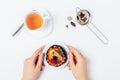 Female hands holding dessert cake next to cup of fresh tea Royalty Free Stock Photo