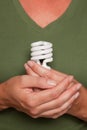 Female Hands Holding Energy Saving Light Bulb