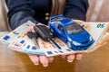 Female hands holding euro, toy car and keys Royalty Free Stock Photo