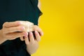 Female hands holding face powder on yellow background Royalty Free Stock Photo