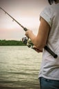 Female hands holding a fishing rod Royalty Free Stock Photo