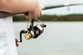 Female hands holding a fishing rod and twist the handle of the f Royalty Free Stock Photo