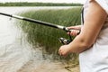 Female hands holding a fishing rod and twist the handle Royalty Free Stock Photo